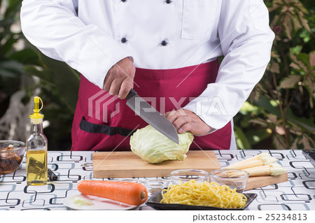 Chef cutting cabbage on wooden broad 25234813