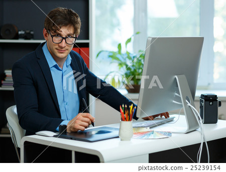 Handsome young man working from home office Handsome young man working from home office 25239154