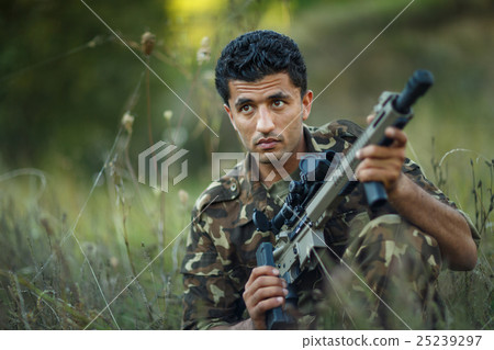 Man of Arab nationality in camouflage with a gun 25239297