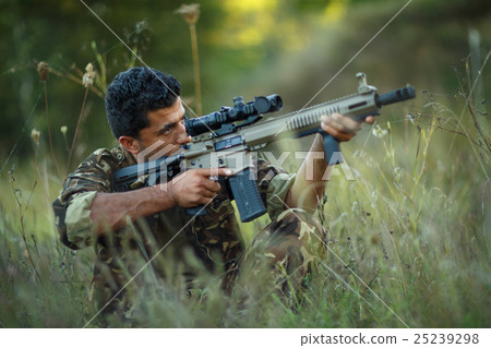 Man of Arab nationality in camouflage with a gun 25239298