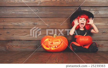 funny child girl in witch costume  for Halloween with pumpkin Ja 25239363