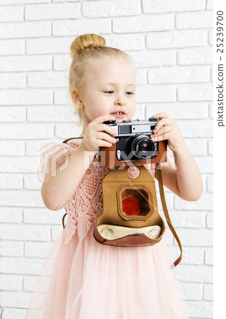 Little girl with retro camera in hand Little girl with retro camera in hand 25239700