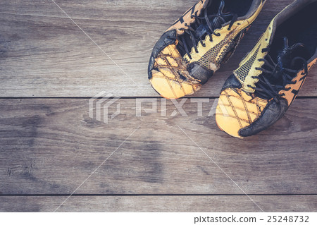 Old football shoes on grey wooden plank Old football shoes on grey wooden plank 25248732