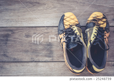 Old football shoes on grey wooden plank Old football shoes on grey wooden plank 25248739