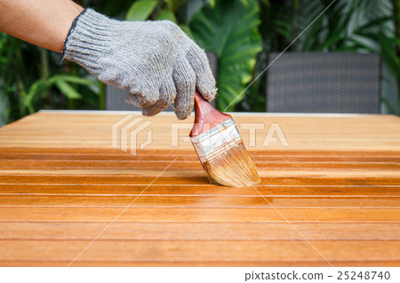 Brush in hand and painting on the wooden table 25248740