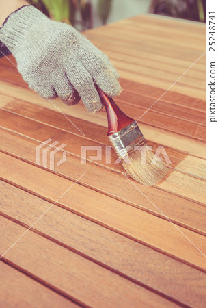 Paintbrush in hand and painting on the wooden table. Retro and vintage style Paintbrush in hand and painting on the wooden table. Retro and vintage style 25248741