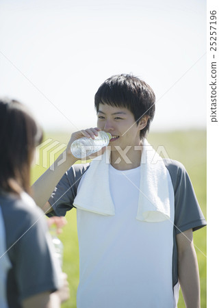 A couple that hydrates on the grass A couple that hydrates on the grass 25257196