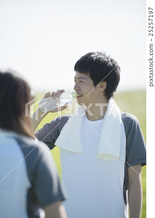 A couple that hydrates on the grass A couple that hydrates on the grass 25257197