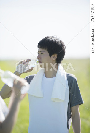 在草地上保濕的男人 在草地上保濕的男人 25257199