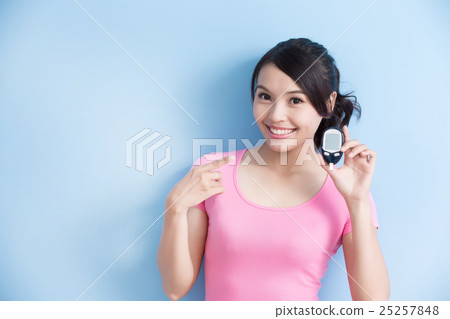 woman holding blood glucose meter woman holding blood glucose meter 25257848