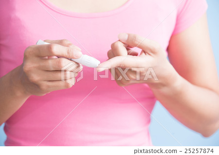 woman holding  blood glucose meter 25257874