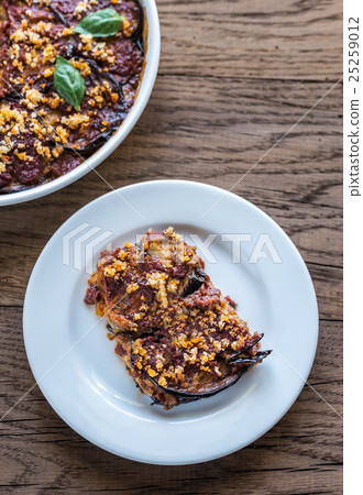 Dish and portion of parmigiana di melanzane 25259012