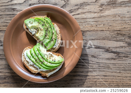 Toasts with tahini sauce and sliced avocado Toasts with tahini sauce and sliced avocado 25259026