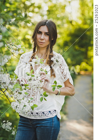Portrait of a girl on a background of a flowering shrub 6111. 25261023