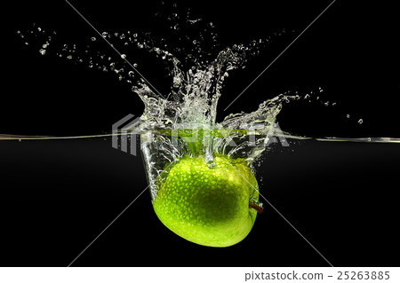 Green apple falling in water on black background 25263885