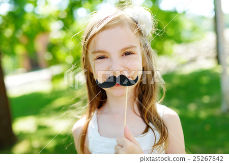 Adorable little girl playing with paper moustache 25267842