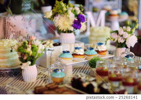 Decorated colorful cupcakes on a dessert table 25268141