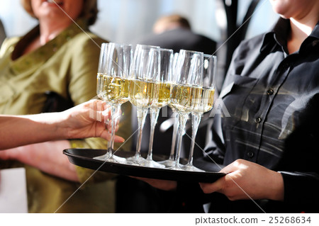 Waitress holding a dish of champagne, wine glasses Waitress holding a dish of champagne, wine glasses 25268634