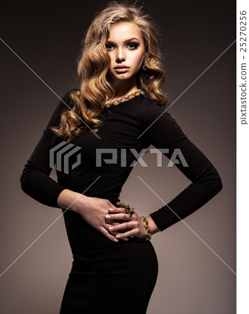 Beautiful woman in black bodycon dress with long curly hair 25270256