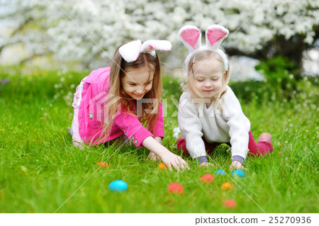 Two little sisters hunting for easter egg on Easter day Two little sisters hunting for easter egg on Easter day 25270936