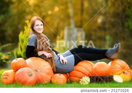 Beautiful young woman having fun on a pumpkin patch Beautiful young woman having fun on a pumpkin patch 25271026