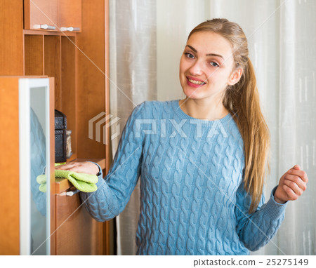 Young woman doing regular clean-up at living room Young woman doing regular clean-up at living room 25275149