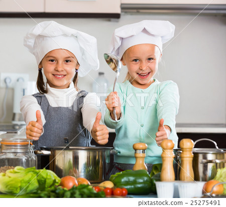 Two cheerful girls cooking vegetable soup 25275491