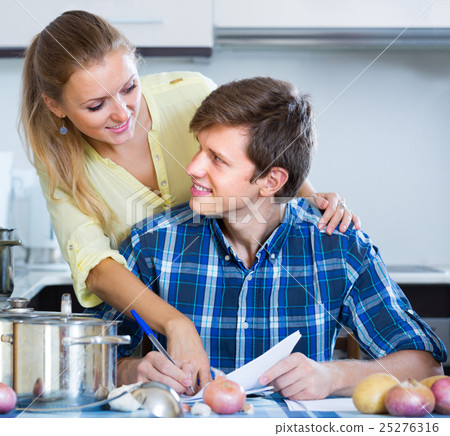 Happy spouses filling forms for joint banking Happy spouses filling forms for joint banking 25276316