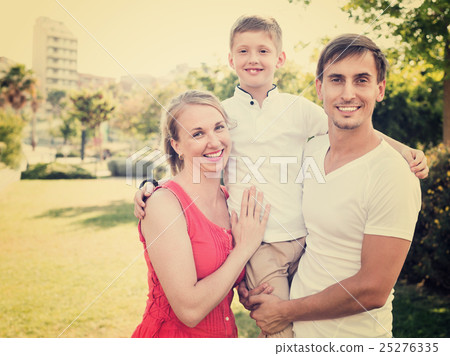 Portrait of cheerful family with boy in school age happily hugging each Portrait of cheerful family with boy in school age happily hugging each 25276335