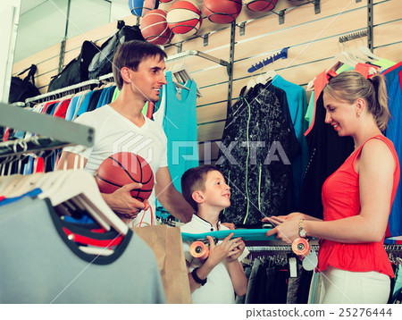 Family of three choosing skateboard in store. Family of three choosing skateboard in store. 25276444