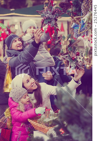 Happy family choosing christmas decorations Happy family choosing christmas decorations 25276445