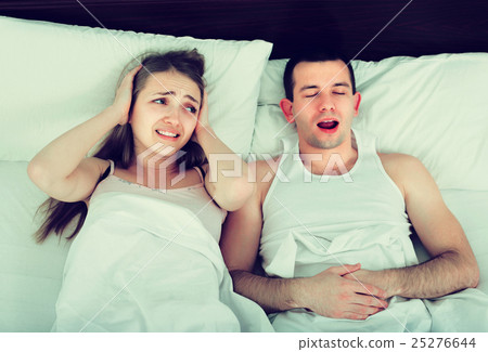 Young woman disturbed with partner snores . Young woman disturbed with partner snores . 25276644