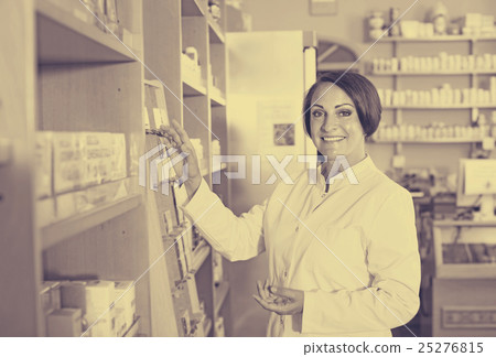 Smiling mature woman seller standing in pharmacy 25276815