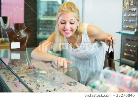 Customer looking jewellery gifts in glass showcase 25276840