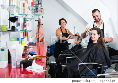 Smiling woman getting hairdo of male hairdresser 25277136