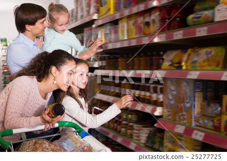 Adult couple with small kids purchasing jam 25277725