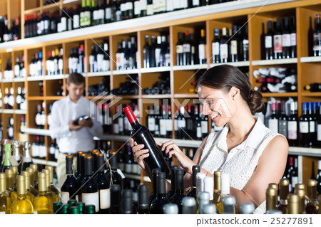 female customer in wine store. 25277891