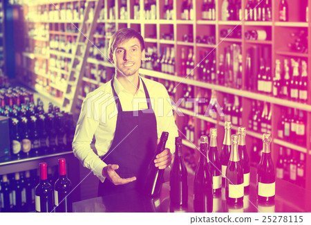 Man seller wearing uniform having bottle of wine 25278115