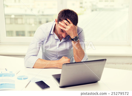 businessman with laptop and papers in office 25279572