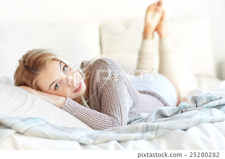 happy young woman lying in bed at home happy young woman lying in bed at home 25280282