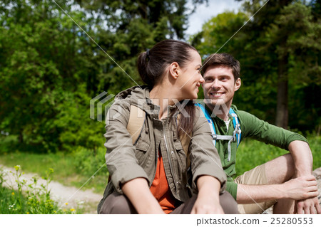 smiling couple with backpacks in nature 25280553