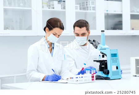 scientists with clipboard and microscope in lab 25280745