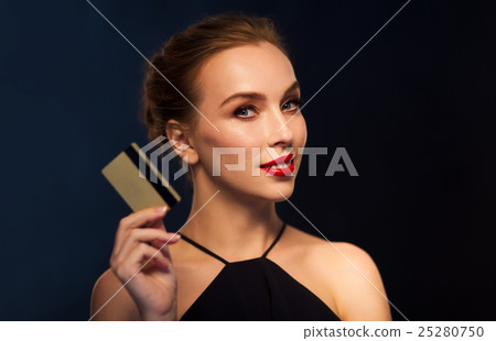 beautiful woman with credit card over black 25280750