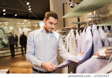 happy young man choosing clothes in clothing store 25281037