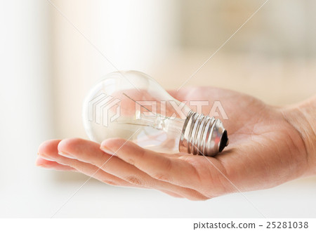 close up of hand holding edison lamp or lightbulb 25281038