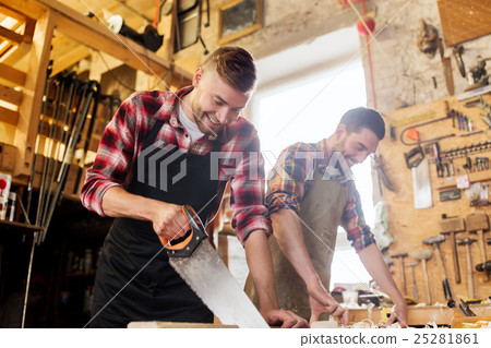 carpenters working with saw and wood at workshop carpenters working with saw and wood at workshop 25281861