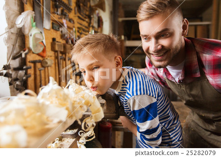 father and little son with wood plank at workshop 25282079
