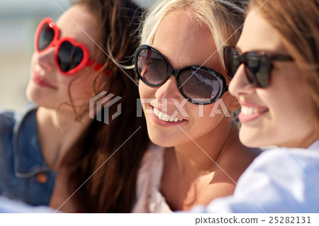 group of smiling women taking selfie on beach 25282131