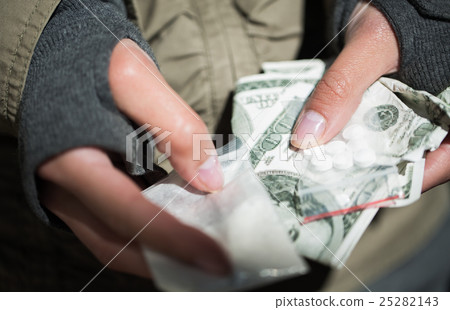 close up of addict hands with drugs and money close up of addict hands with drugs and money 25282143