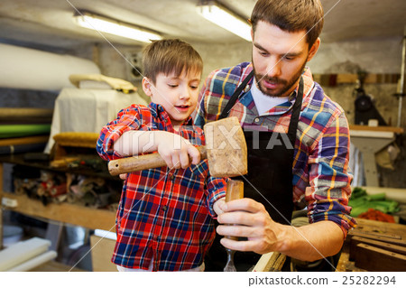 father and son with chisel working at workshop father and son with chisel working at workshop 25282294
